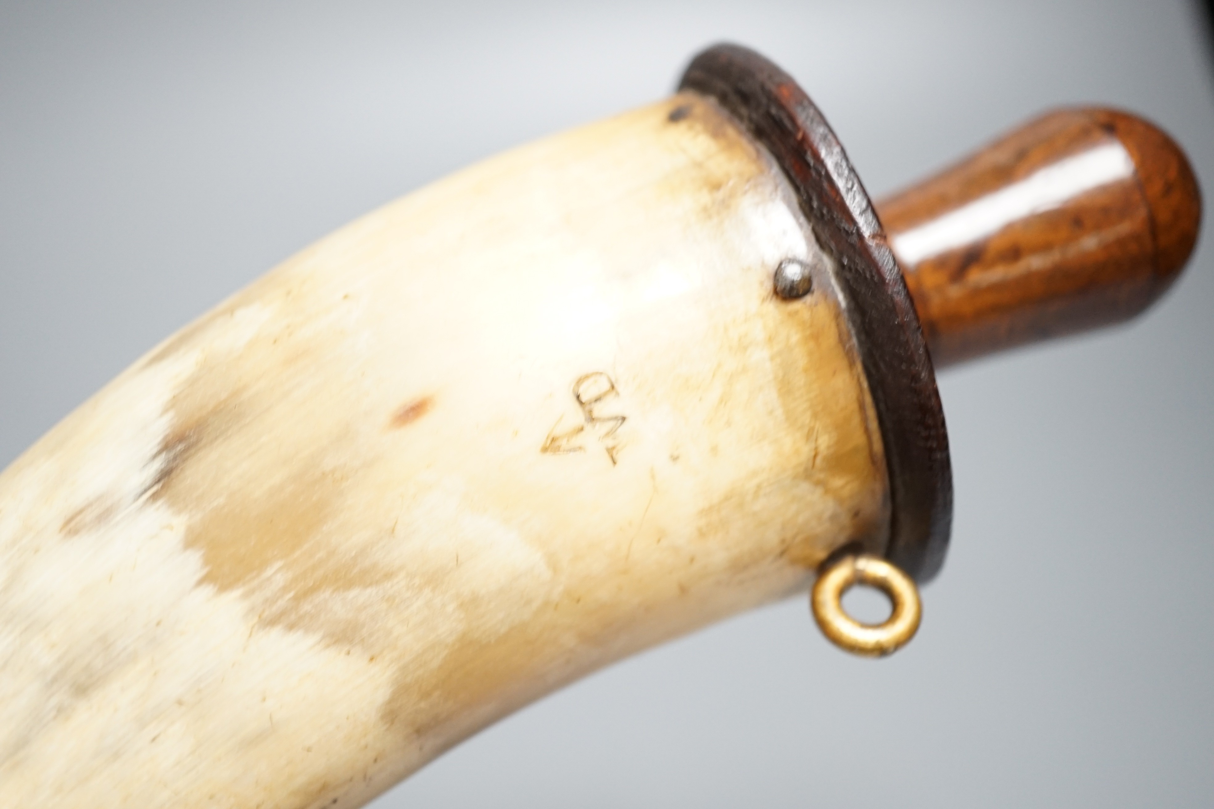 A British military Gunner's powder horn c.1800, cow horn body, sprung brass charger, wooden end cap and plug, two brass suspension rings, body branded with WD stamp and broad arrow. Length 29cms.